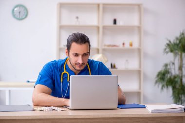 Klinikte çalışan genç erkek doktor.