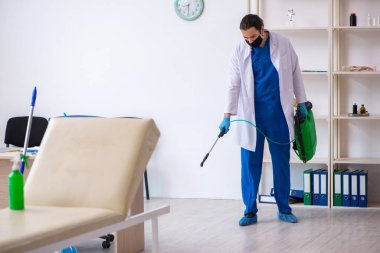 Genç erkek müteahhit salgın konseptinde dezenfekte kliniği