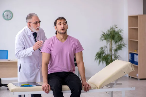 Young male patient visiting old male doctor — Stock Photo, Image