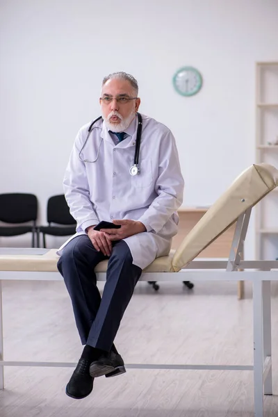 Klinikte çalışan yaşlı erkek doktor. — Stok fotoğraf