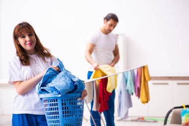 Evde ütü yapan genç bir çift.