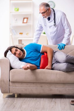 İki doktor hasta bir genci ziyaret ediyor.