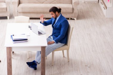 Evden kendini izole etme konseptiyle çalışan genç bir erkek işçi.