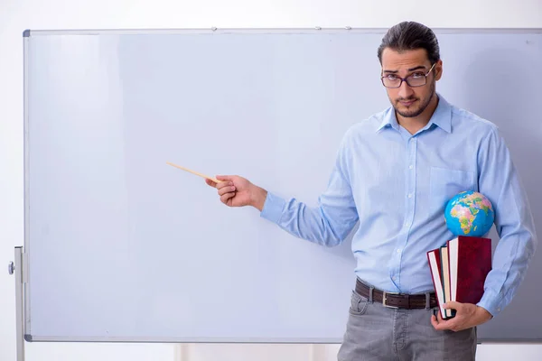 Jeune professeur de géographie masculine devant le tableau blanc — Photo