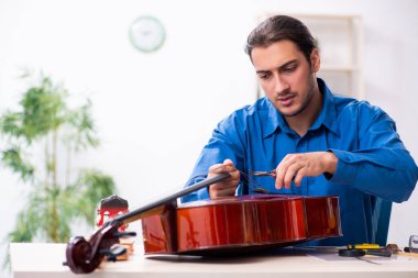 Genç erkek çello tamircisi.