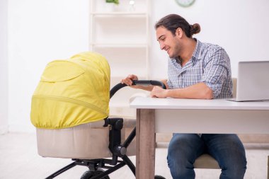 Genç baba yeni doğan bebeğe evde bakıyor.