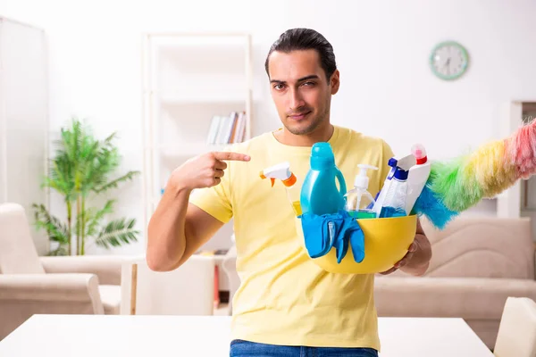 Jonge mannelijke aannemer doet huishoudelijk werk thuis — Stockfoto