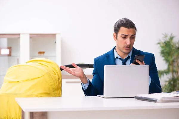 Jungunternehmer kümmert sich zu Hause um Neugeborenes — Stockfoto