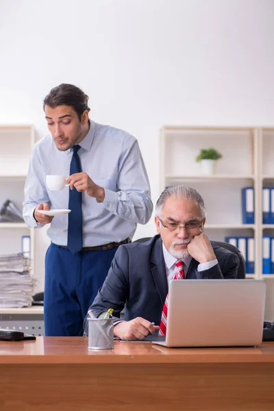 Old boss and young male employee in the office — Stock Photo, Image