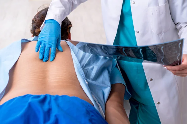 Joven hombre lesionado de espalda visitando quiropráctico médico femenino — Foto de Stock