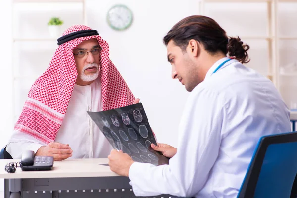 Old male arab visiting young male doctor — Stock fotografie