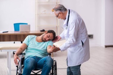 Tecrübeli doktor ve tekerlekli sandalyedeki genç hasta.