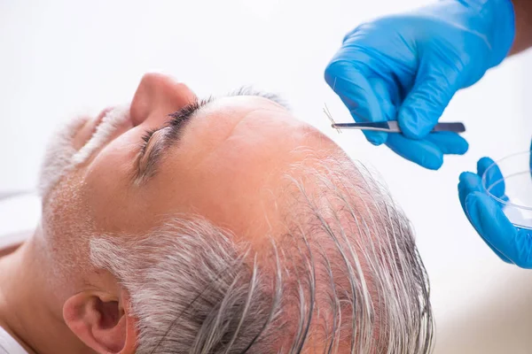 Starý muž návštěva mladý muž lékař v transplantaci vlasů conce — Stock fotografie