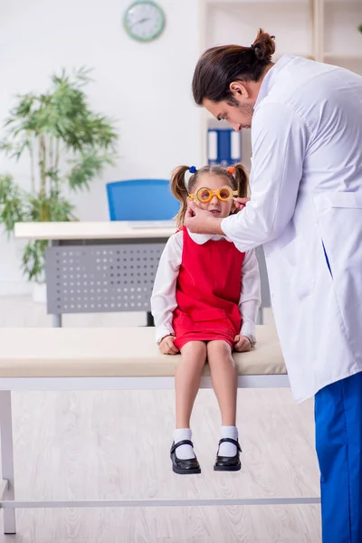 Piccola ragazza in visita giovane medico maschio oculista — Foto Stock