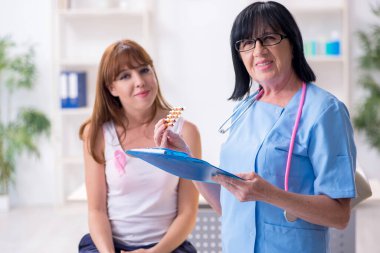 Genç bir kadın yaşlı doktor onkolojisti ziyaret ediyor. Göğüs kanseri.