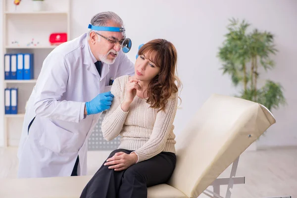 Young woman visiting old male doctor otorhinolaryngologist — Stock Photo, Image