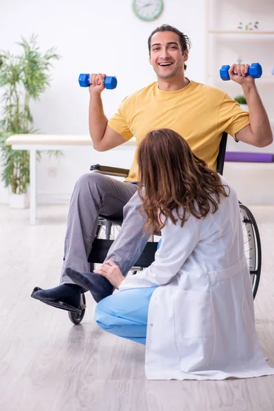 Joven paciente masculino en silla de ruedas haciendo ejercicios físicos — Foto de Stock