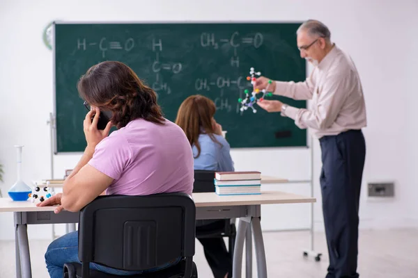 Antiguo profesor de química y dos estudiantes en el aula —  Fotos de Stock