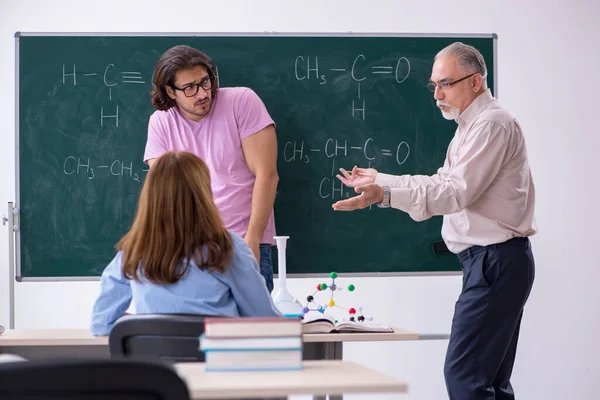 Antiguo profesor de química y dos estudiantes en el aula — Foto de Stock