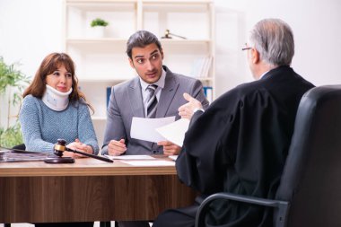 Yargıç ve avukatla birlikte adliyede genç bir kadın.