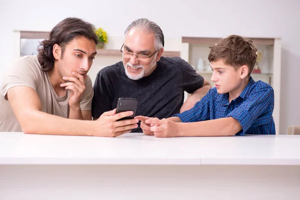 Grandfather learning new technology from son and grandson