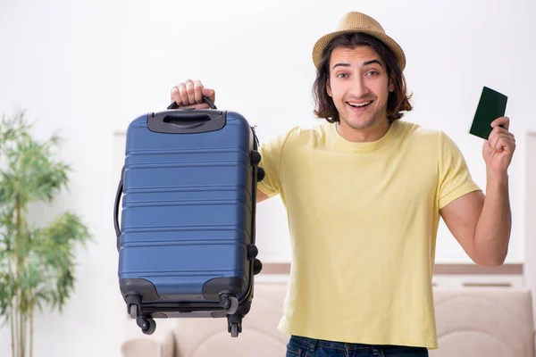 Young man holding passport and suitcase preparing for trip — Stock Photo, Image