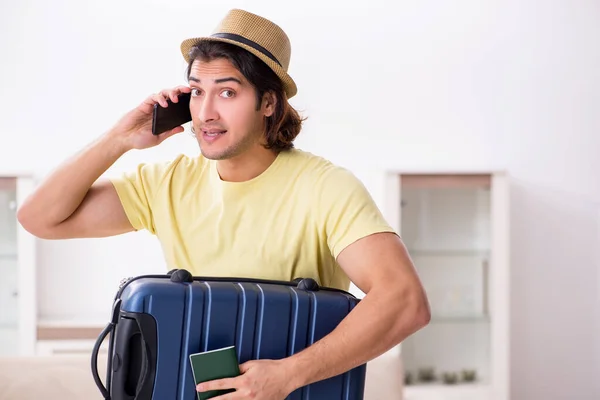 Молодий чоловік тримає паспорт і валізу, готуючись до поїздки — стокове фото