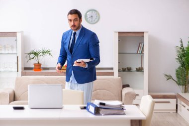 Evden kendini izole etme konseptiyle çalışan genç bir erkek işçi.