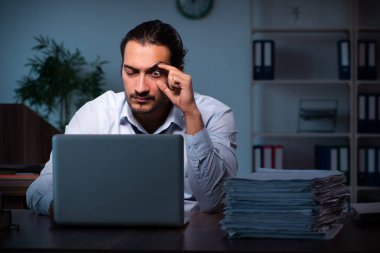 Gece ofiste çalışan genç bir erkek.