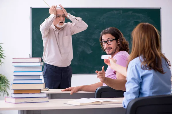 Old chemist teacher and two students in the classroom — Stock Photo, Image