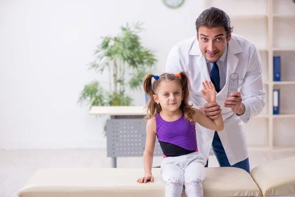 Menina pequena visitando jovem médico masculino — Fotografia de Stock