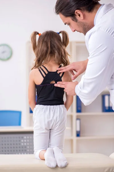 Menina pequena visitando jovem médico masculino — Fotografia de Stock