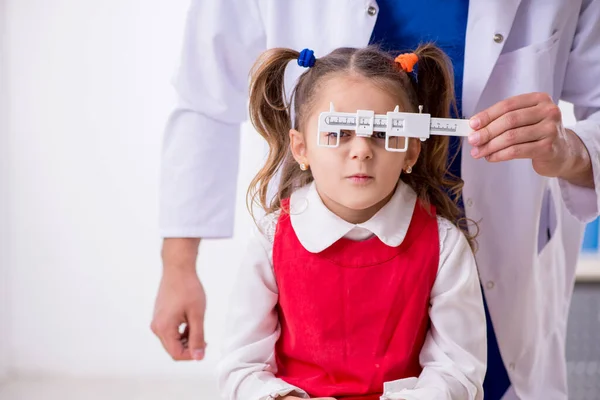 Kleines Mädchen besucht junge männliche Augenärztin — Stockfoto