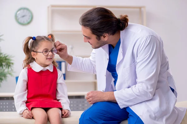 Piccola ragazza in visita giovane medico maschio oculista — Foto Stock