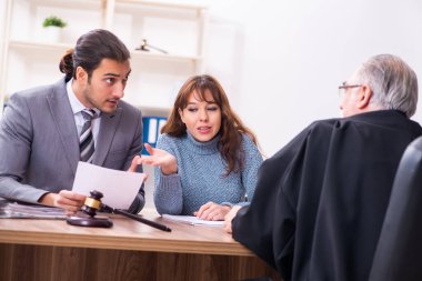 Yargıç ve avukatla birlikte adliyede genç bir kadın.