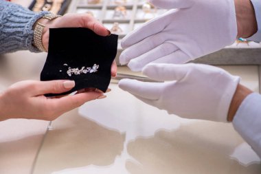 Mağazada erkek kuyumcu ve bayan müşteri