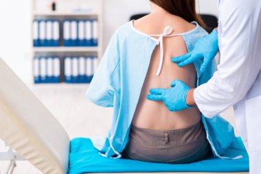 Yaralı genç kadın genç erkek doktoru ziyaret ediyor.