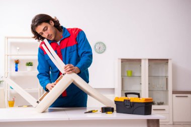 Genç erkek marangoz içeride çalışıyor.