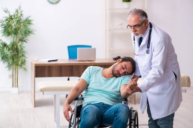 Tecrübeli doktor ve tekerlekli sandalyedeki genç hasta.