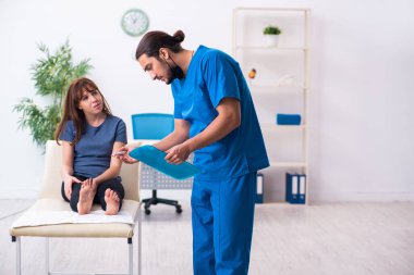 Erkek doktor travmatoloğu ziyaret eden yaralı bir kadın.