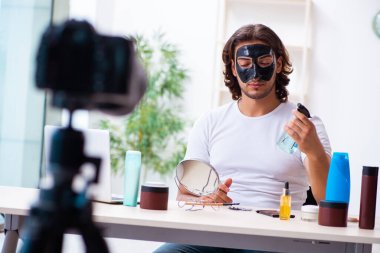 Genç erkek kozmetikçi blogu için video kaydediyor.