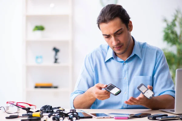 Joven técnico masculino reparando teléfono móvil —  Fotos de Stock