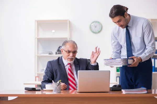 Old boss and young male employee in the office — Stock Photo, Image