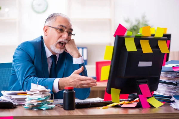 Alte Mitarbeiter arbeiten im Büro in widersprüchlichen Prioritäten — Stockfoto