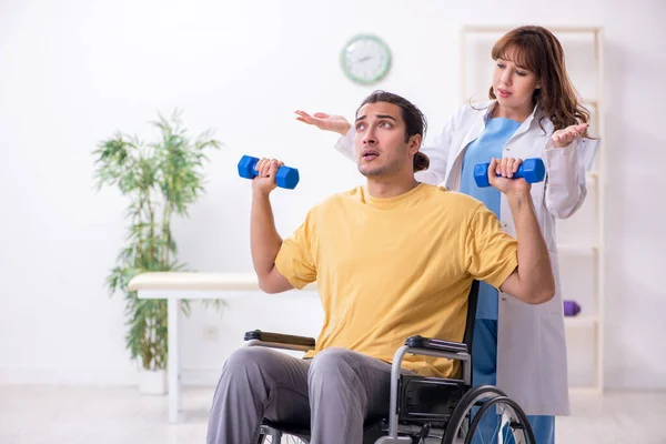 車椅子の若い男性患者は、物理的な演習を行う — ストック写真