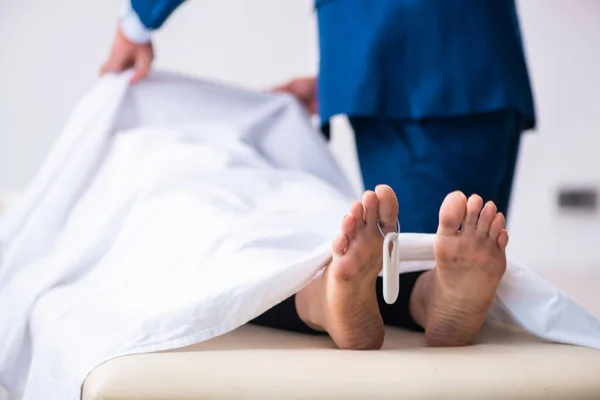Gerichtsmediziner untersucht Leiche in Leichenhalle — Stockfoto
