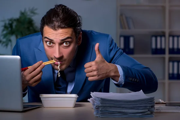 Funcionário com fome trabalhando até tarde no escritório — Fotografia de Stock