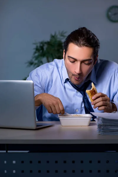 Empleado hambriento trabajando hasta tarde en la oficina — Foto de Stock