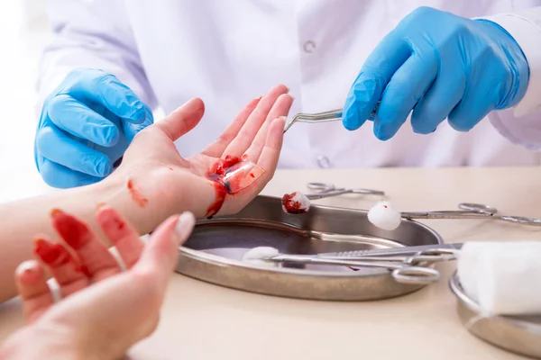 Femme blessée à la main visitant médecin masculin — Photo