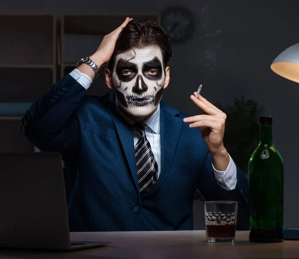 Uomo d'affari con maschera spaventosa che lavora fino a tardi in ufficio — Foto Stock